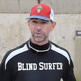 Person wearing a cap and 'Blind Surfer' shirt against a plain background